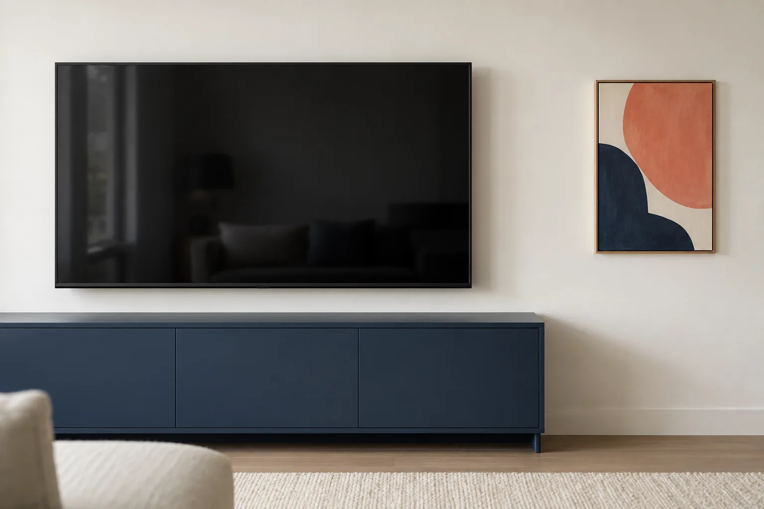 A small coral abstract artwork positioned beside a television with clear space around the screen.